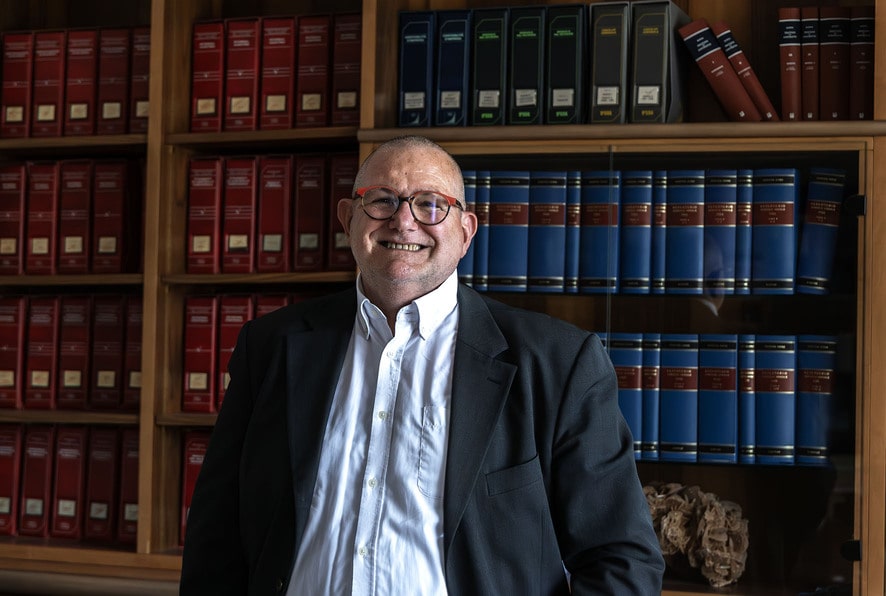 foto a mezzo busto dell'Avvocato Piero Gallimberti in piedi con alle spalle una libreria
